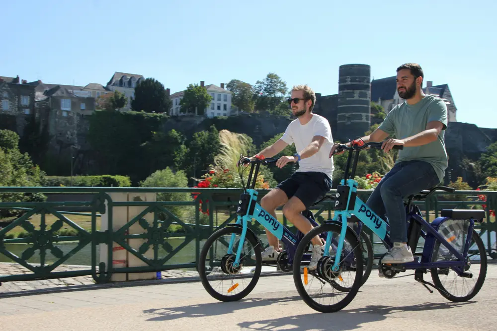 สถานีบริการจักรยานไฟฟ้าให้เช่า (Pony Bikes) สองแห่งในเขตเมือง แสดงให้เห็นถึงจุดจอดและจุดชาร์จไฟสาธารณะ